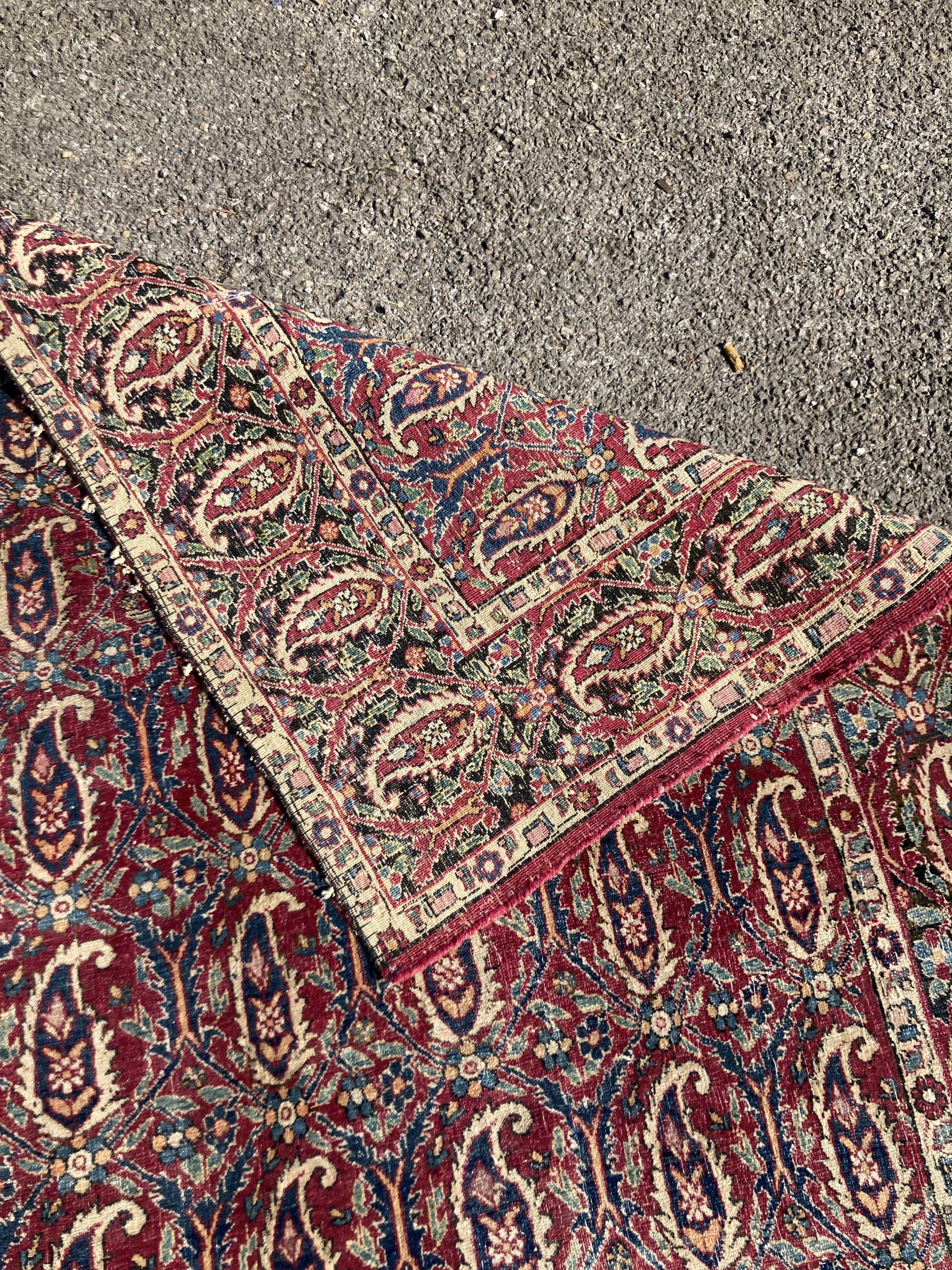 An early 20th century Persian Senneh red ground rug woven with rows of Boteh 218 x 130 cms